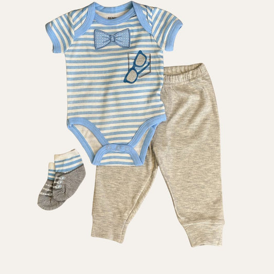 The 3-Piece Baby Boy's Summer Set in Blue & White Stripes by Alaya Junior includes a blue and white striped onesie adorned with a bowtie and glasses design, complemented by light beige pants featuring an elastic waistband, and matching socks. The onesie is detailed with light blue borders and fasteners at the bottom. This set is perfect for newborn baby clothing in Pakistan.