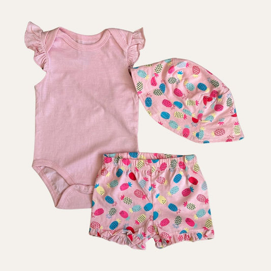 The "Alaya Junior 3 Pcs Baby Girl Summer Vibe Sunny Pineapple Delight Set" is a charming pink baby outfit for newborns in Pakistan. It includes a sleeveless onesie with ruffled shoulders, matching shorts, and a hat. The shorts and hat feature an adorable colorful hedgehog pattern with hues of blue, yellow, green, and red on a pink background.