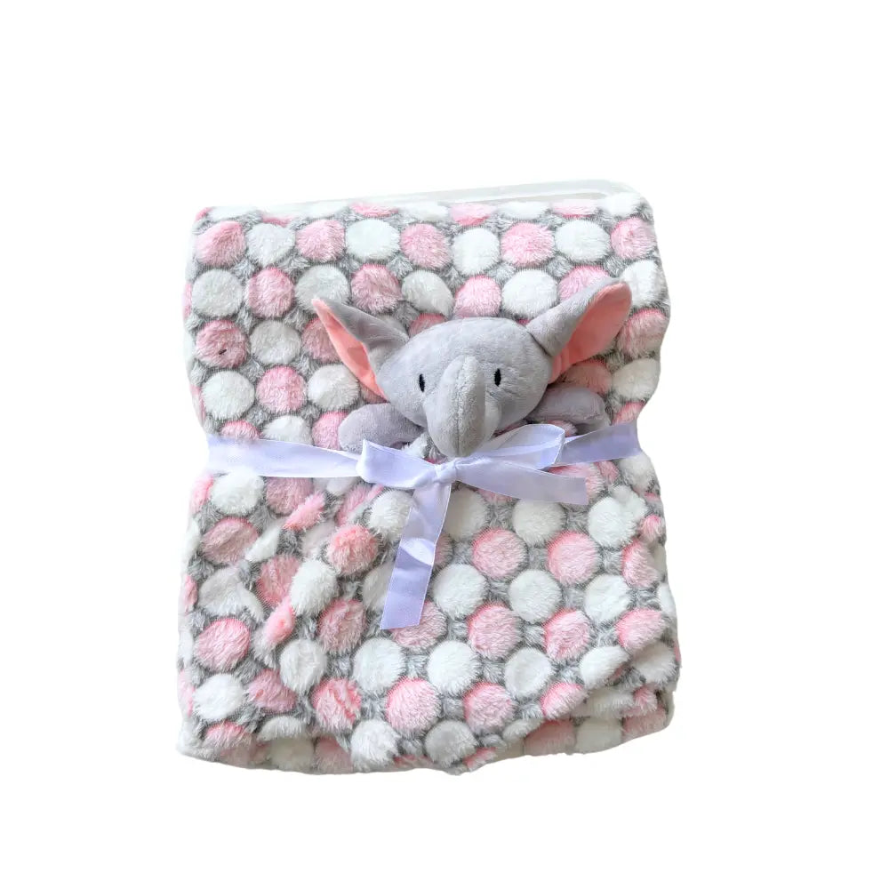 The "Soft Baby Blanket with Cute Plush Toy" by Alaya Junior features a soft, multicolored baby blanket adorned with large pink and white polka dots and tied with a white ribbon. Nestled in the center of the folded blanket is an adorable gray elephant plush toy with floppy ears, adding a sweet touch to the charming animal patterns.