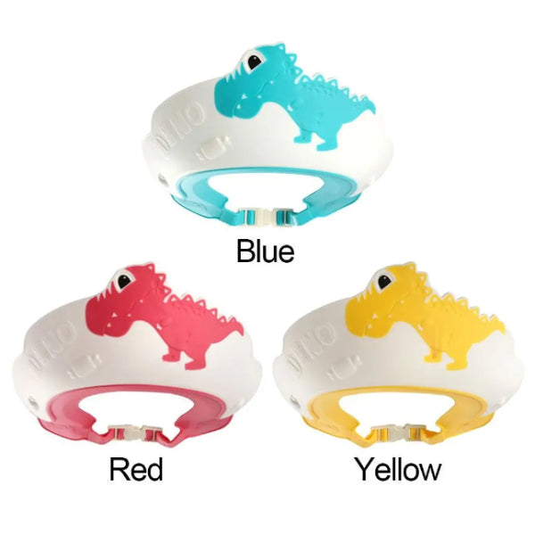 Three adjustable dinosaur-themed shower caps for kids are showcased, made from child-friendly materials. Each cap displays a fun dinosaur design in different colors: blue, red, and yellow, complete with corresponding text labels. They feature a secure opening at the bottom to ensure safety during bath time. Brand: Alaya Junior.