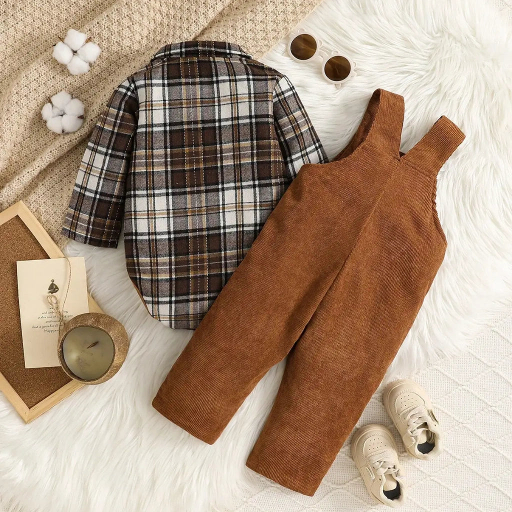 Brown plaid shirt and overalls on a textured surface with decorative items.