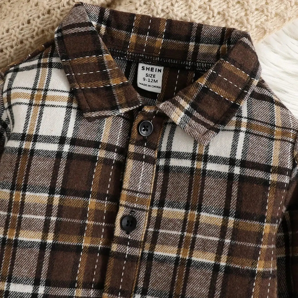 Plaid shirt with collar and buttons, brand label visible, on a textured surface.