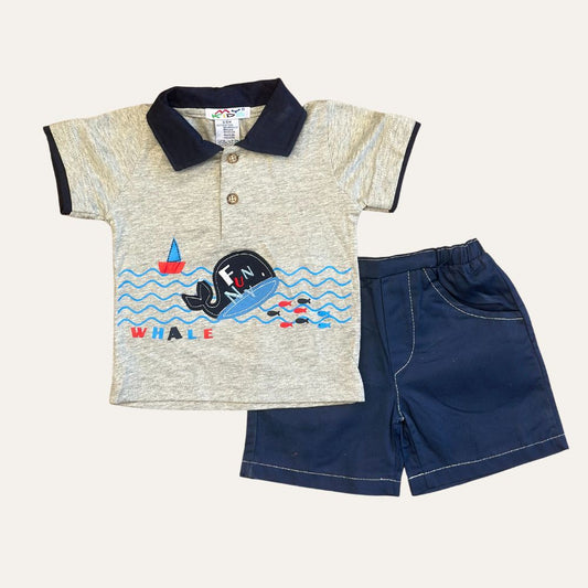 The Baby Boy 2 Pcs Whale Shirt And Short Set by Alaya Junior consists of a gray short-sleeve polo shirt with a navy collar and a playful whale design featuring the word "FUN WHALE," paired with navy blue shorts. This delightful outfit, perfect for baby clothing in Pakistan, is made in Thailand and showcased against a plain white background.