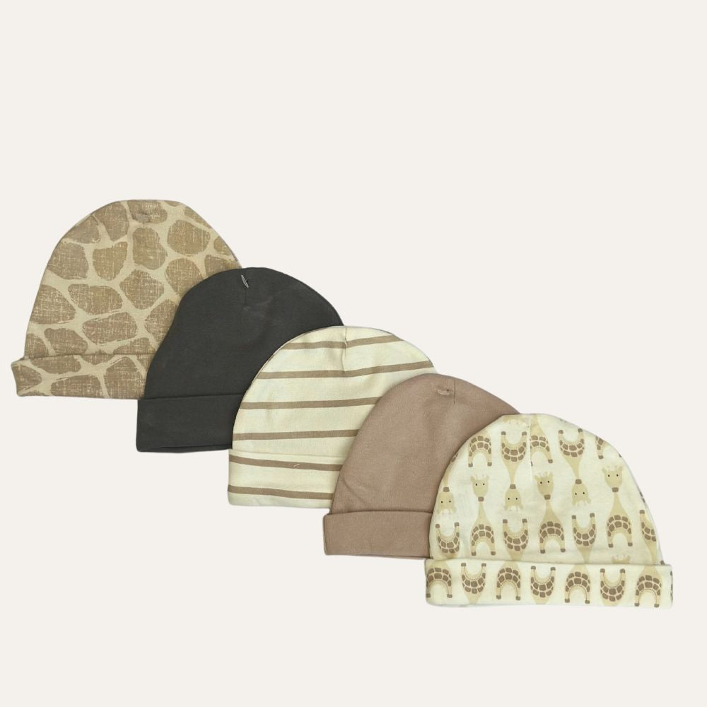 Five baby hats from Alaya Junior's "Cuddly Caps for Little Boys: 5-Pack of Beige Infant Hats" are displayed in a row, perfect for any newborn. They come in different colors and patterns: light brown with bear faces, dark brown, beige with cream stripes, solid light brown, and cream with a teddy bear pattern. The hats are arranged from left to right on a plain background.