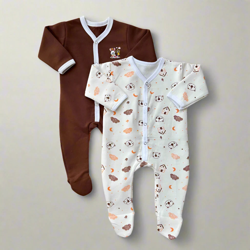 The Juniors Winter Baby Rompers Pack of 2 (Brown Set) by Carter's showcases adorable and cozy infant onesies. One romper is solid brown adorned with a small embroidered bear patch, while the other is cream-colored featuring a charming pattern of bears, trees, and clouds. Both rompers include snap closures down the front for convenient changing.