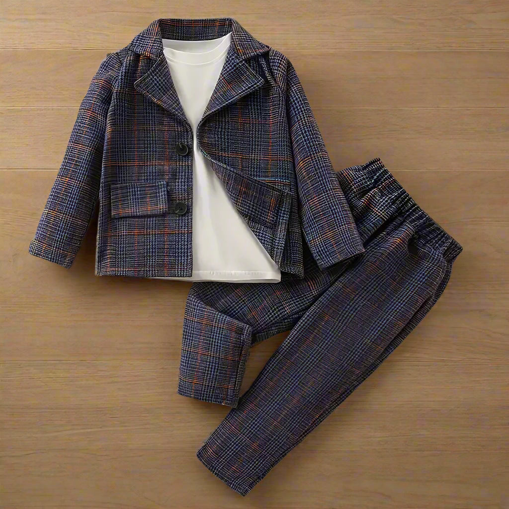 The SHEIN Baby Boy Plaid Print Lapel Neck Blazer & Pants, in dark plaid shades of blue, orange, and gray without the tee, offer style and comfort for any occasion. Perfect for pairing with a white T-shirt against a wooden background.