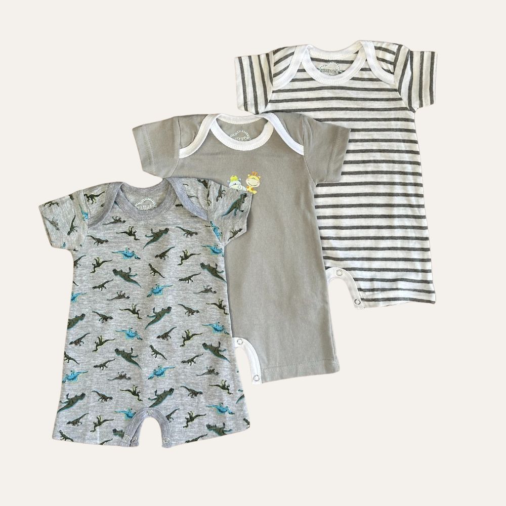 Three baby rompers from the Alaya Junior collection are displayed side by side. The left romper features playful dinosaur motifs on breathable cotton blend fabric, the middle romper is plain grey with small animal designs near the collar, and the right romper has grey and white horizontal stripes. All these pieces are part of Carters' Unisex Grey Dinosaur and Stripe 3 Romper Set - Summer Essentials, showcasing a gender-neutral design.