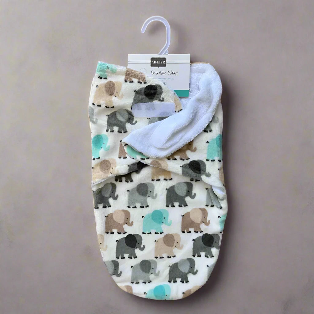 The Cozy Winter Swaddle with Elephant Design by Alaya Junior showcases an adorable elephant pattern in gray, brown, and teal hues on a cream background. It ensures comfort for your baby and is presented against a neutral backdrop, featuring a label and hanger at the top.