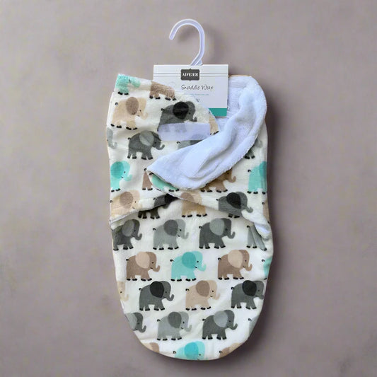 The Cozy Winter Swaddle with Elephant Design by Alaya Junior showcases an adorable elephant pattern in gray, brown, and teal hues on a cream background. It ensures comfort for your baby and is presented against a neutral backdrop, featuring a label and hanger at the top.