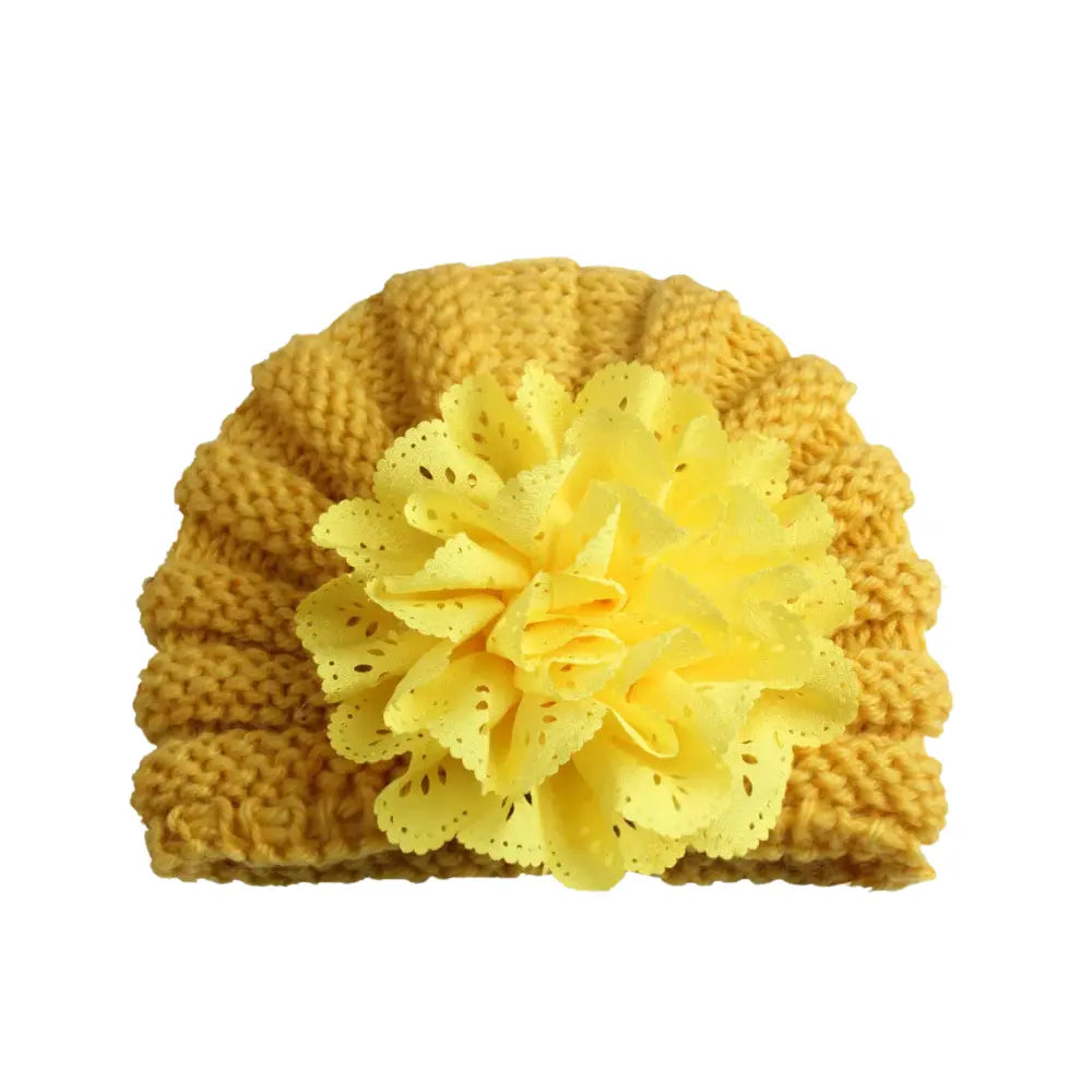This Baby Girl Lace Flower Design Knitted Turban Cap by Alaya Junior is a charming yellow beanie adorned with a large decorative flower on the front. The multi-layered, textured petals provide a playful accent to this versatile accessory. Set against a white backdrop, it’s ideal for adding flair to any outfit for babies aged 0 months to 3 years.