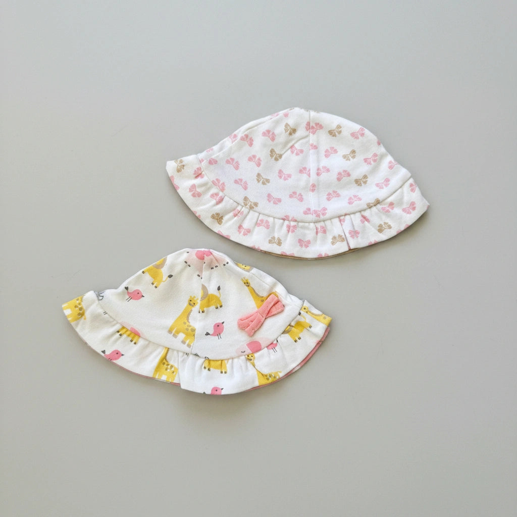 Two baby hats with floral and animal patterns on a brown background