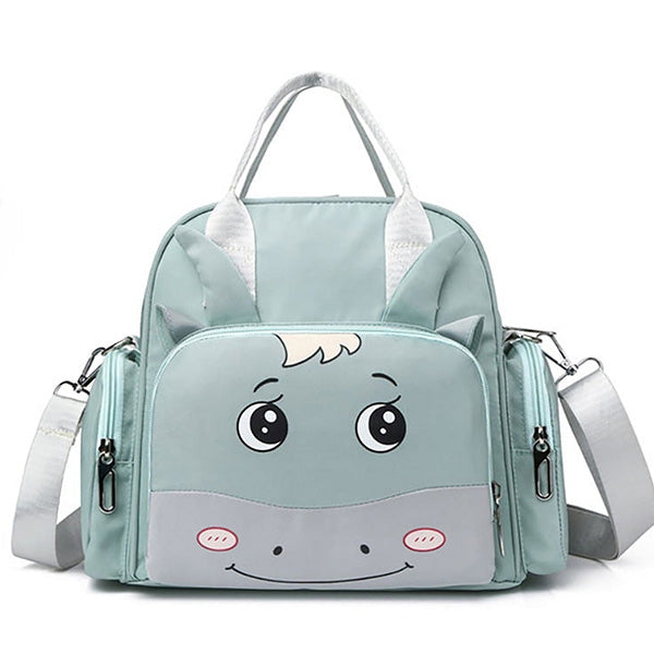 The Alaya Junior Luxury Multi-function Mother Backpack is a light green children's bag featuring a cute cartoon unicorn face with big eyes, a small smile, and a tuft of white hair. Perfect for carrying baby clothing items from Pakistan, this fashionable and waterproof diaper bag includes a large front pocket, two side pockets, dual handles, and an adjustable shoulder strap.