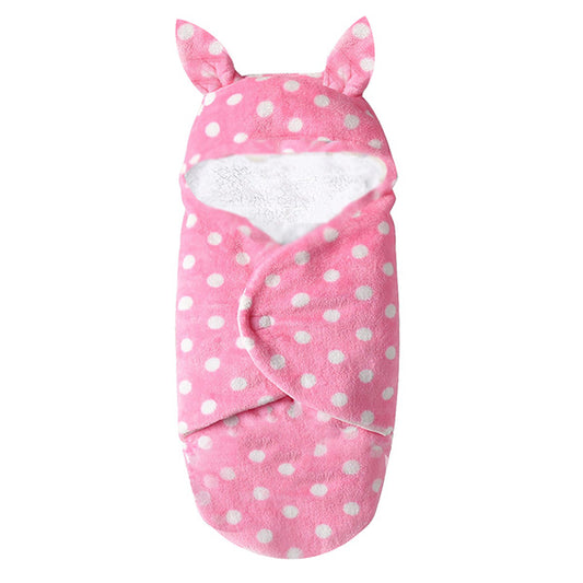 Introducing the Pink Snuggle ultra-soft fleece sleeping bag/swaddle for newborns by Alaya Junior. This adorable baby essential features a charming design with white polka dots and two small ear-like protrusions at the top, perfect for swaddling your little one in comfort.
