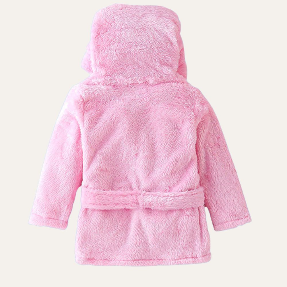 A back view of Alaya Junior's Cotton Baby Bathrobe with Hood in a pink, fluffy design perfect for newborn babies. This bathrobe boasts a soft, plush texture and features a matching belt around the waist. Ideal for those looking for quality infant clothing in Pakistan.