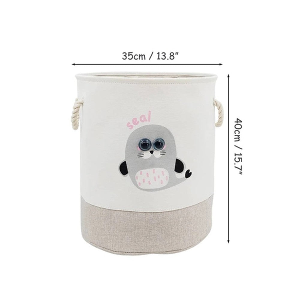 The SHEIN Kids Large Folding Laundry Basket, featuring a cute seal design, is perfect for children. It has rope handles, measures 35 cm in diameter and 40 cm in height, with a beige lower section and white upper part.