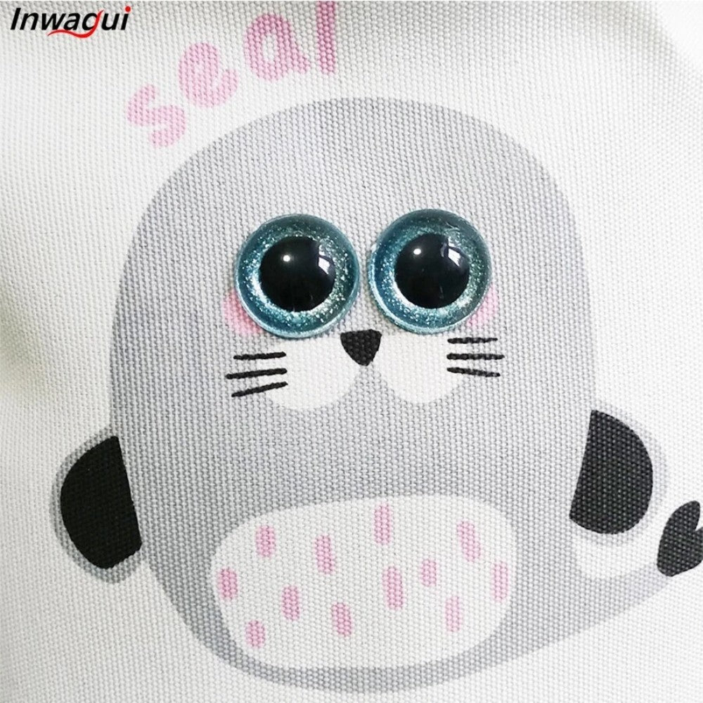 The SHEIN Kids Large Folding Laundry Basket features a cute cartoon seal with large blue eyes, gray body, white belly with pink spots, small black tail, and "seal" written in pink aboveβperfect for kids' rooms.
