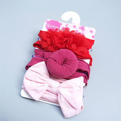 Introduce a touch of baby girl fashion with the Baby Girls' Adorable Trio Three-Piece Headband Set from Alaya Junior. These delightful hair accessories feature charming designs in shades of red and pink, including flowers, a knot, and a large bow.