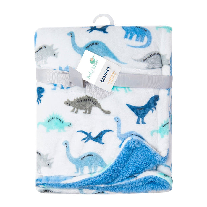 Introducing Alaya Junior's Luvable Friends' Dino Delight: a unisex Sherpa-backed plush blanket featuring a charming dinosaur print in blue, gray, and teal on a white background. Perfect for welcoming little ones into their Dino Dreamland. The ultra-plush front is folded neatly and secured with a gray ribbon. The tag reads "Dino Delight Blanket.