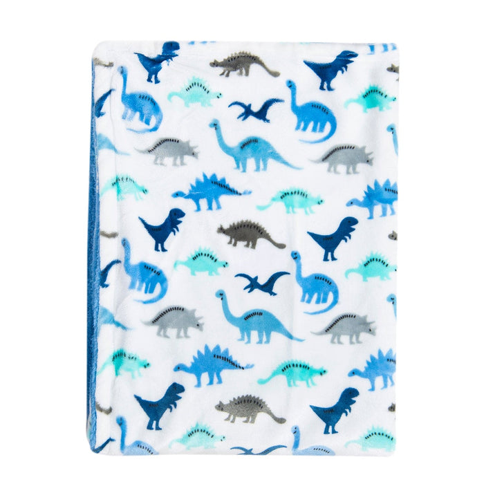 The Dino Delight: Unisex Sherpa-Backed Plush Blanket by Alaya Junior features a cozy, Ultra-Plush Front with a playful array of blue and gray dinosaurs, including T-rex, triceratops, and pterodactyls, against a white backdrop. It's perfect for little explorers dreaming in their Dino Dreamland.