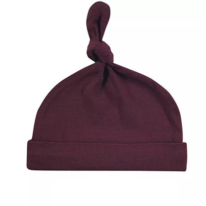 The Hudson Baby Infant Boy Cotton Cap by Alaya Junior, part of the Vintage Little Man collection for newborns aged 0-6 months, is designed in maroon and made from super soft cotton. It features a knotted top and folded rim, making it an essential addition to any baby wardrobe for gentle warmth. Displayed elegantly against a white background.