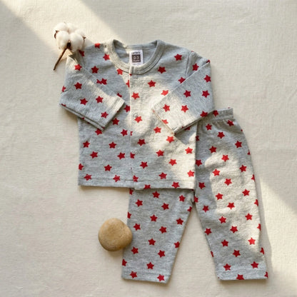 Children's pajama set with red star pattern on a light background