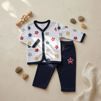 Children's outfit with star-patterned cardigan and navy pants on a beige surface.