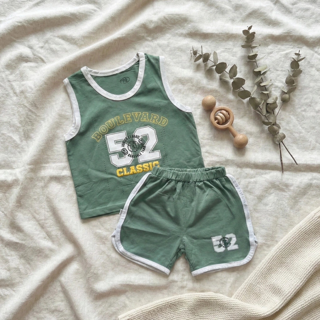 Green children's tank top and shorts set with 'Boulevard Classics' text on a beige fabric background.