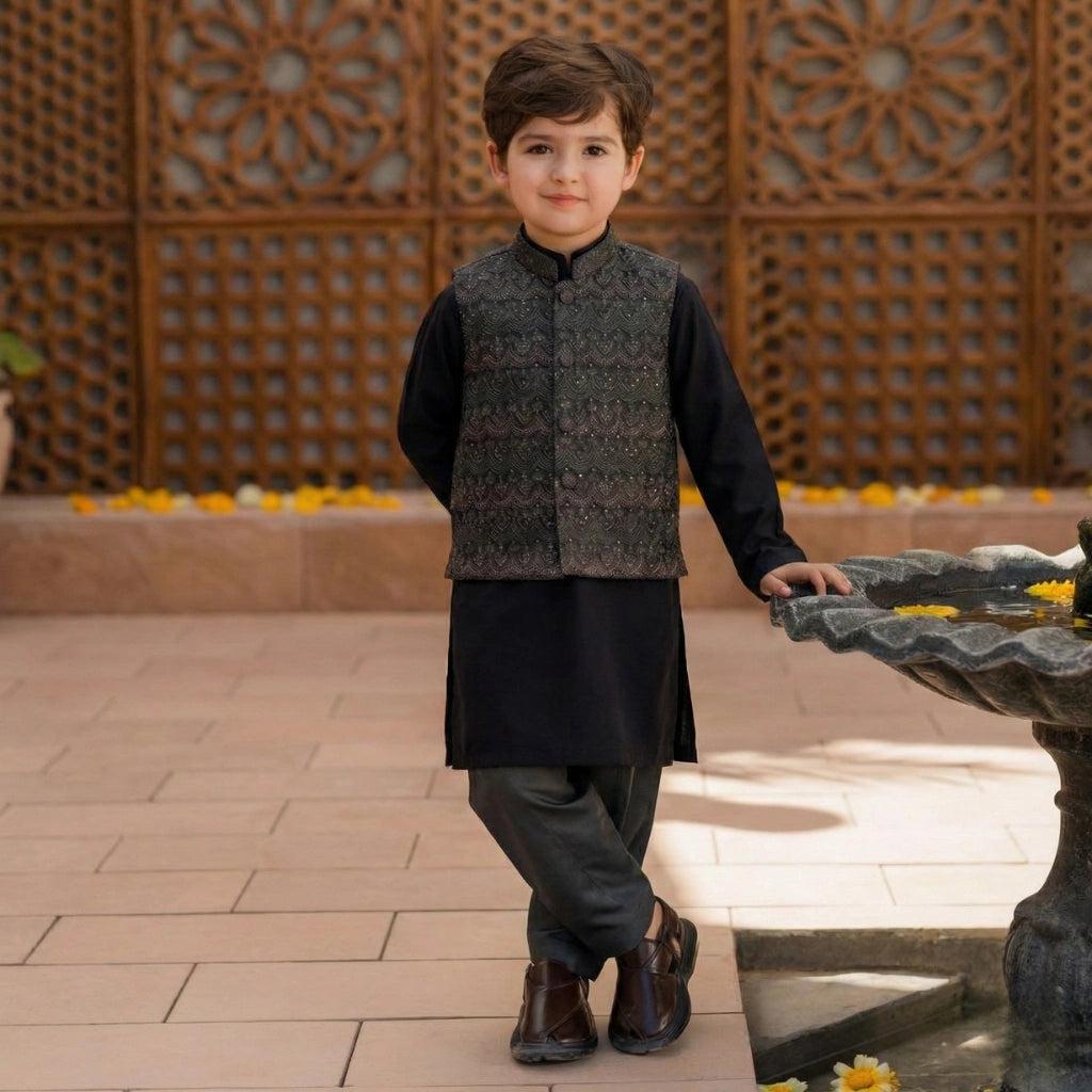 Young boy in traditional attire standing near a decorative fountain.