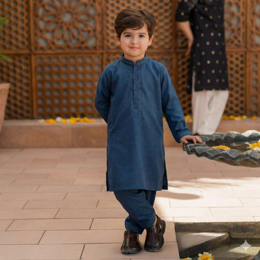Child in a blue traditional outfit standing outdoors with decorative elements in the background