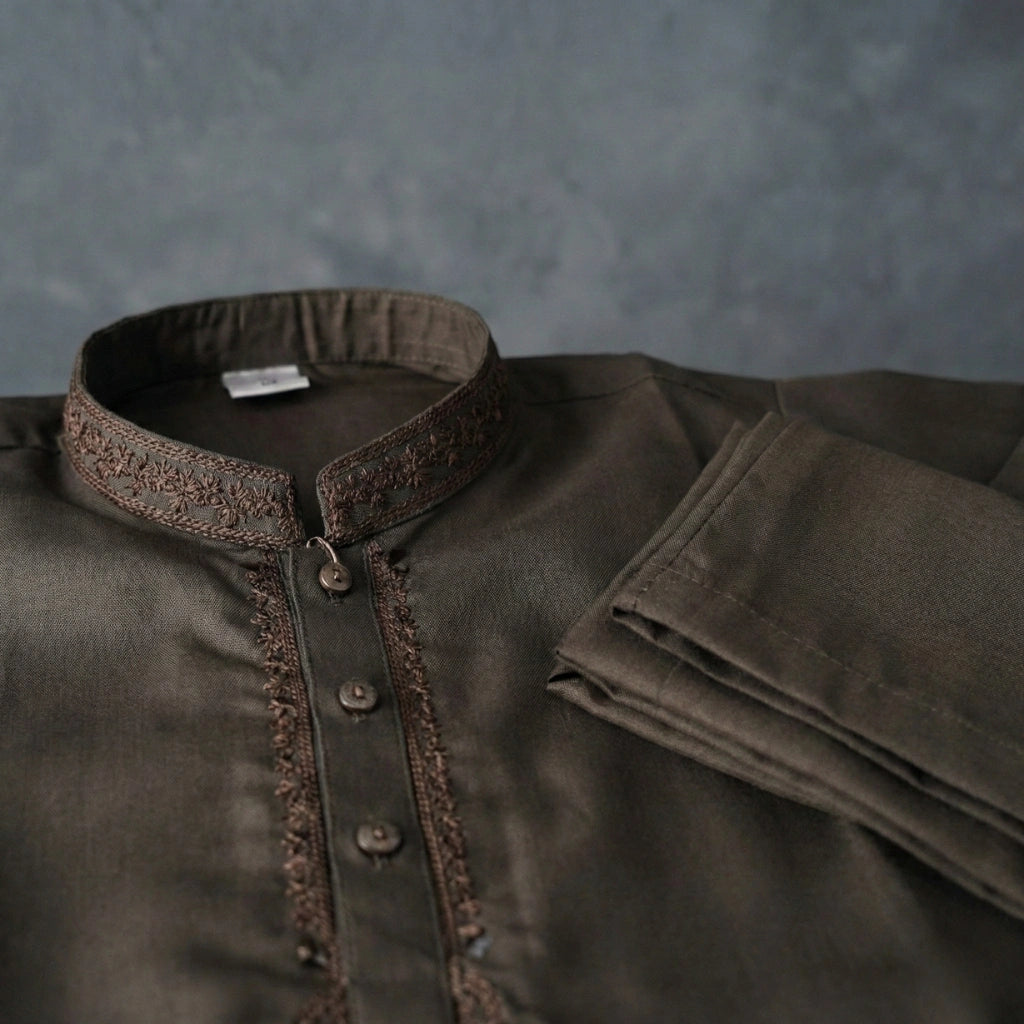 Brown shirt with intricate collar design on a textured gray background