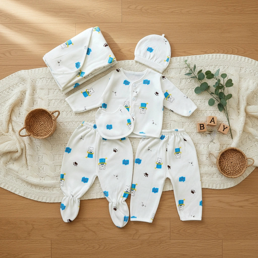 Baby clothing set with onesie, pants, and hat on a wooden floor with decorative elements.
