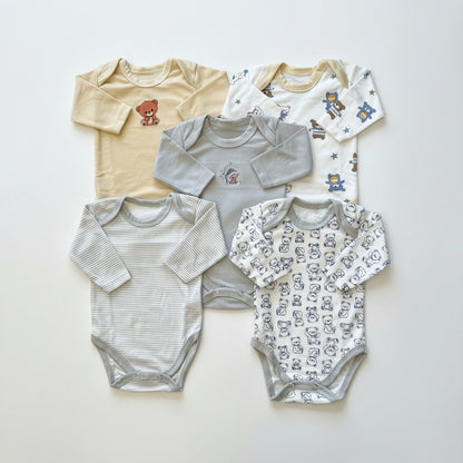Five long-sleeve baby bodysuits arranged in a flat lay on a light off-white background. The set includes a cream bodysuit with a teddy bear graphic, a light gray bodysuit with a small chest graphic, a white bodysuit with blue cartoon characters, a white bodysuit with thin gray stripes, and a white bodysuit with a repeating gray bear print.