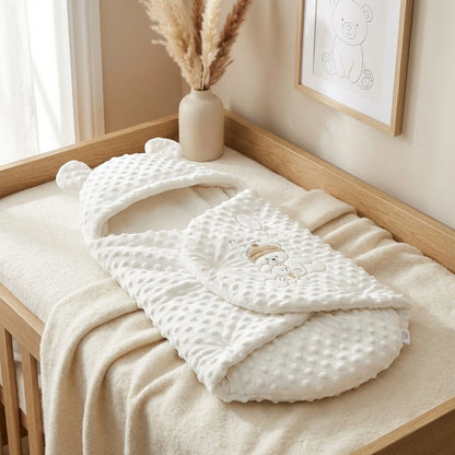 White baby swaddle with bear design on a wooden crib