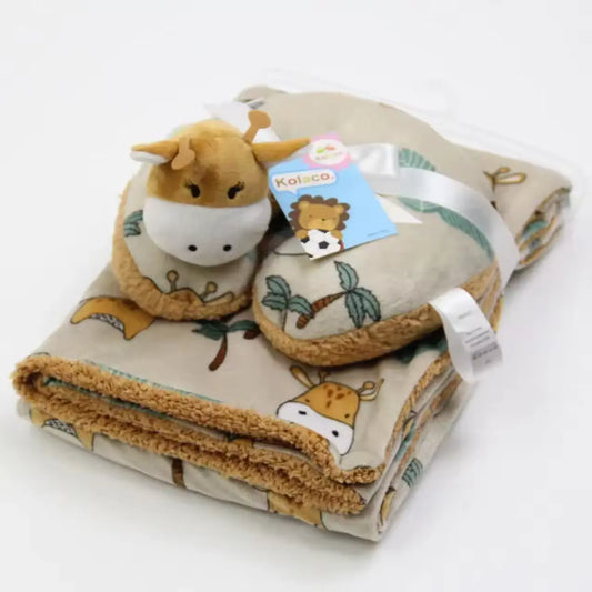 A Cozy Polyester Fleece Neck Pillow and Plush Velvet Baby Blanket from Alaya Junior, featuring an adorable giraffe design with additional animal prints like giraffes and palm trees in soft beige tones, is neatly folded. It includes a pair of cute baby slippers shaped like giraffes with attached tags. The delightful and cozy set is elegantly secured with a white ribbon and placed on a white background.