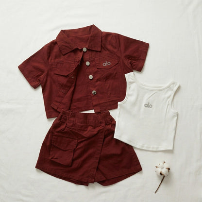 Maroon jacket and shorts with a white tank top on a light background