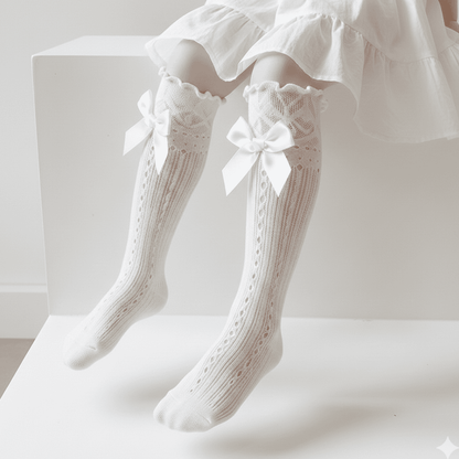 White knee-high socks with lace and bow details on a white background