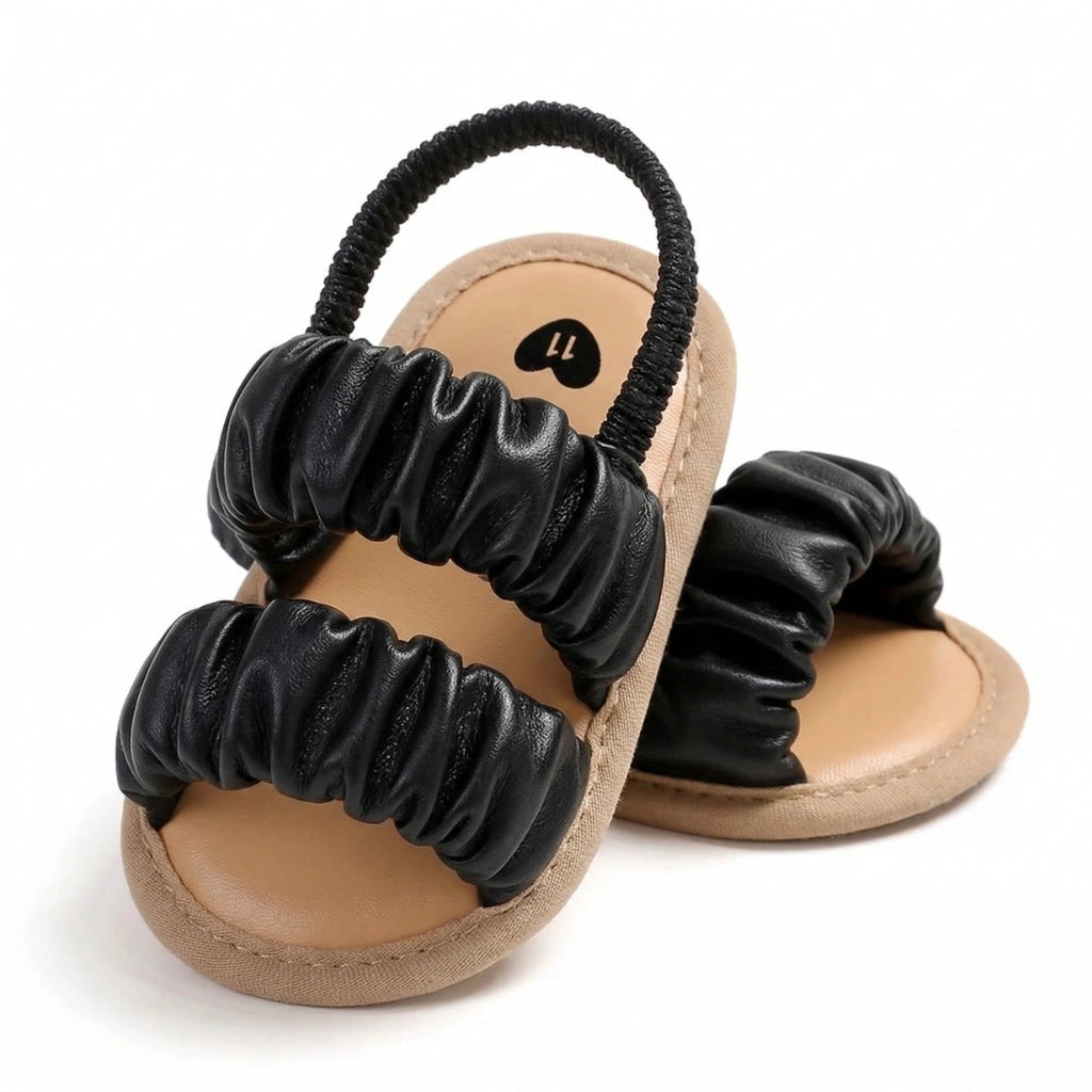 Pair of sandals with black scrunchie straps on a white background