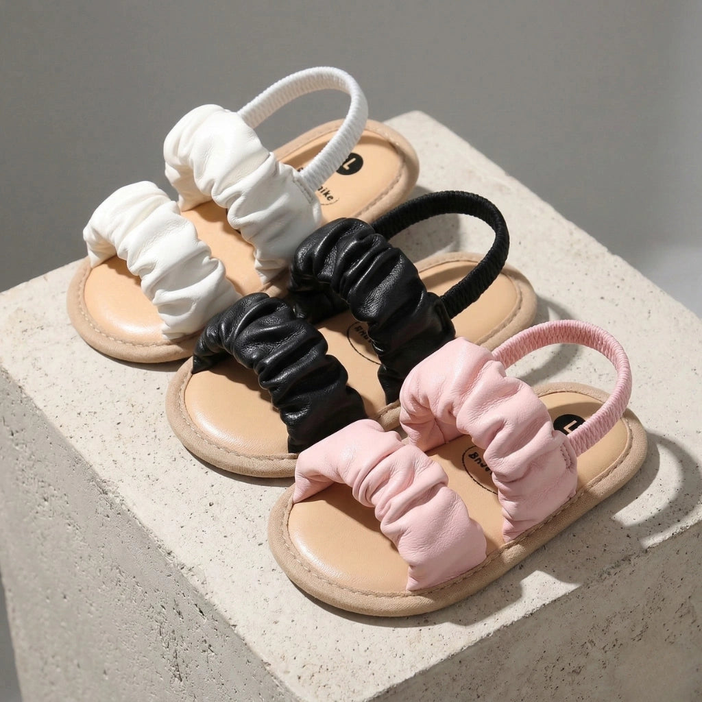 Set of three sandals with scrunchies on a concrete surface