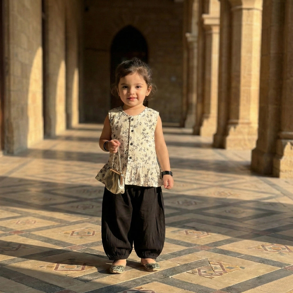 Young girl standing in a sunlit architectural setting with columns and patterned floor.