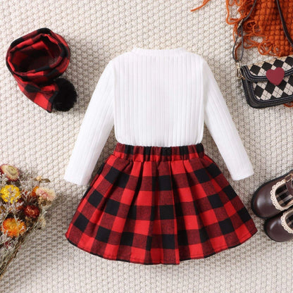 Red ---- White sweater with red plaid skirt on a textured surface with accessories.