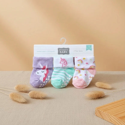 Set of baby socks with packaging on a beige background