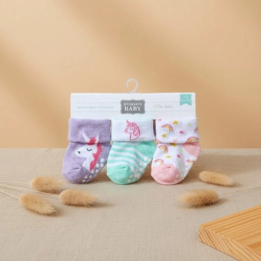 Set of baby socks with packaging on a beige background