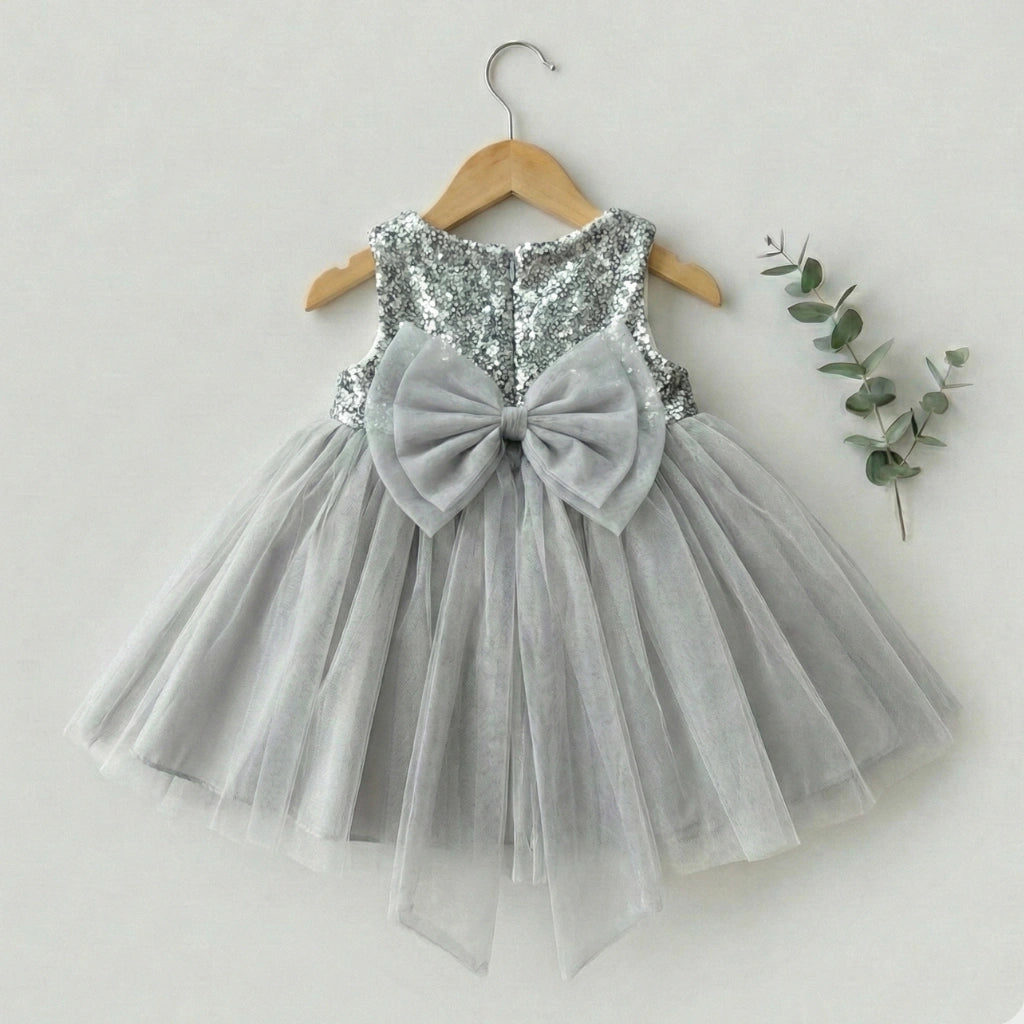 Gray sequin dress with a large bow on a hanger against a white background