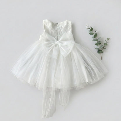 White lace dress with a large bow on a light gray background