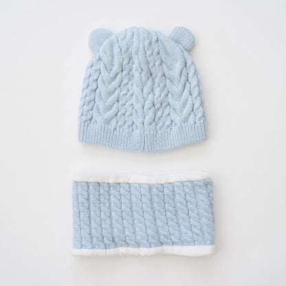 A light blue cable-knit baby beanie with small ear tabs and a matching knit neck warmer, laid flat on a white background.