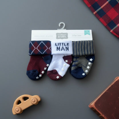 Set of baby socks with 'Little Man' text on a Hudson Baby branded card against a white background
