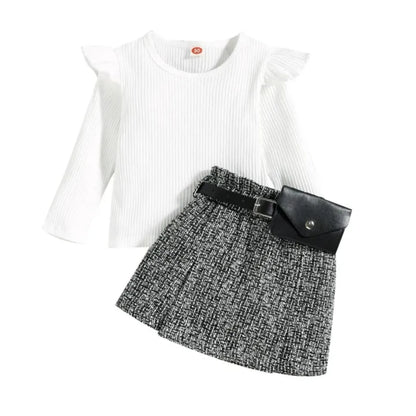 White long-sleeve top and black and gray patterned skirt with a belt on a white background