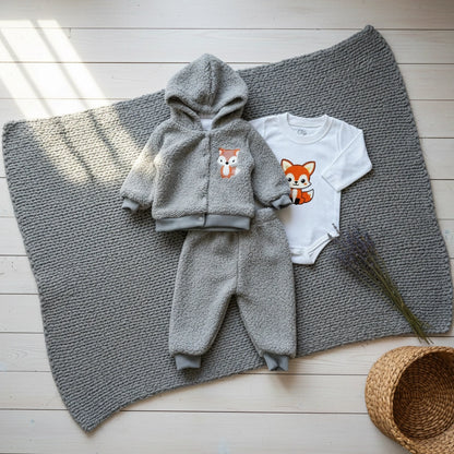 Children's gray fleece set with hood and pants, and a white onesie with fox design on a white background.