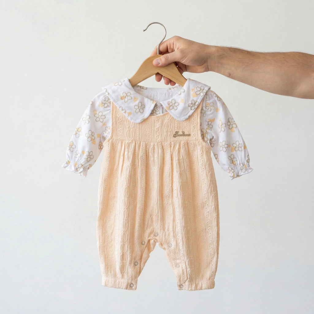 Baby romper with lace collar on a hanger against a white background