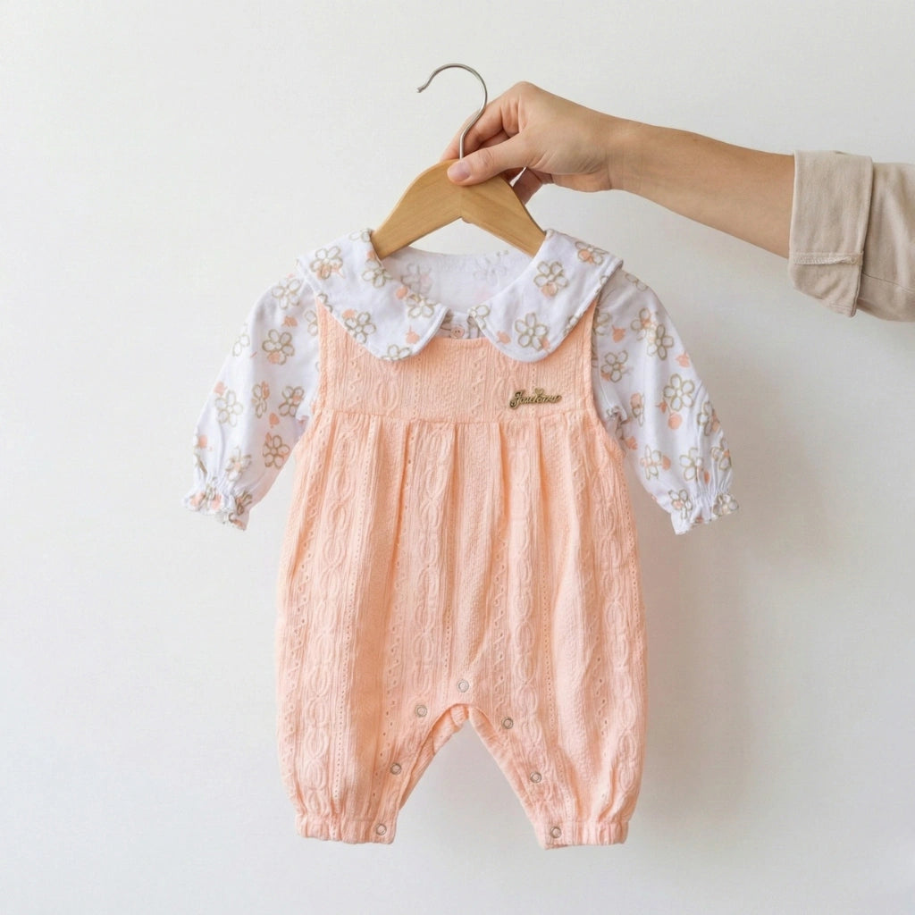 Baby romper with floral lace collar on a hanger against a white background